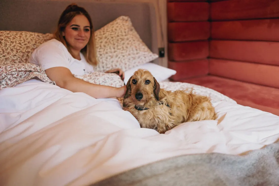 A tenant and her dog relaxing on the bed